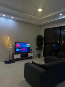 ein Wohnzimmer mit einem Sofa und einem Flachbild-TV in der Unterkunft شاليه ريفان in Umm Lajj