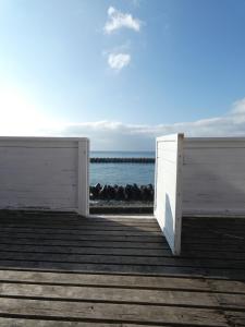 a white door on a boardwalk near the water at Oceanview 貸別荘Hosuikan in Shiraoi