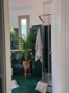 La salle de bains est pourvue d'une douche et d'une plante en pot. dans l'établissement Pontida 27, à Bergame