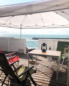 a table and chairs under an umbrella on the beach at Oceanview 貸別荘Hosuikan in Shiraoi