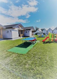 a group of play equipment in a yard with houses at Domki Flaming in Dąbki