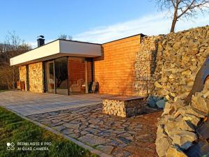 un edificio con una pared de piedra y un banco en Chata pod smrekmi, en Hriňová