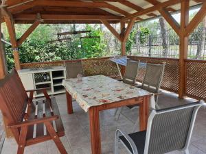 einen Holztisch und Stühle auf einer Terrasse in der Unterkunft Rose Apartman in Balatonlelle