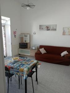 - un salon avec une table et un canapé dans l'établissement Casa al mare Ostuni camerini, à Villanova di Ostuni