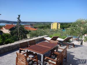 einen Holztisch und Stühle auf einer Terrasse in der Unterkunft Comfortable Apartment Lavanda in Kornić