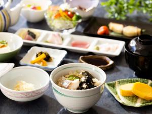 una mesa con tazones de comida y platos de comida en Kujyukushima Seaside Terrace en Sasebo