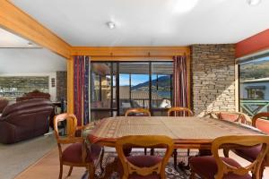 uma sala de jantar com uma mesa de madeira e cadeiras em Charming house with lovely views em Queenstown