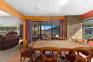 a dining room with a wooden table and chairs at Charming house with lovely views in Queenstown