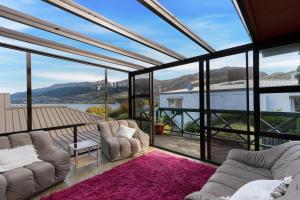 a living room with two couches and a large window at Charming house with lovely views in Queenstown