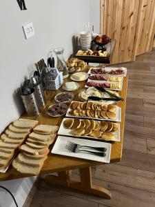 einen Tisch mit verschiedenen Brotsorten und Gebäck in der Unterkunft Kezgin Guest House in Naryn