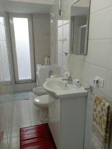 La salle de bains est pourvue d'un lavabo, de toilettes et d'un miroir. dans l'établissement Casa al mare Ostuni camerini, à Villanova di Ostuni