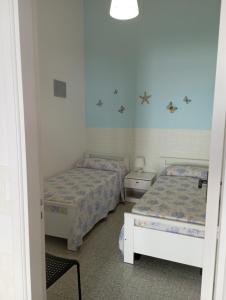 - une chambre avec 2 lits dans une chambre avec une fenêtre dans l'établissement Casa al mare Ostuni camerini, à Villanova di Ostuni