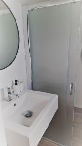 uma casa de banho com um lavatório branco e um espelho. em Domki Flaming em Dąbki