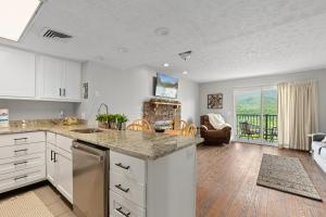 eine Küche mit weißen Schränken und ein Wohnzimmer in der Unterkunft Deer Ridge Mountain Resort A201 in Gatlinburg