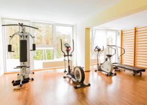 a gym with three exercise bikes in a room at Apartamenty Baltic Inn in Pogorzelica