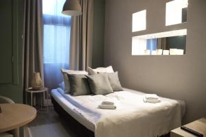 a bedroom with a bed with white sheets and pillows at EURO-ROOM in Krakow