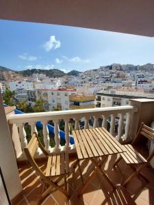 einen Balkon mit einer Bank und Stadtblick in der Unterkunft Apartamento Jacaranda in La Herradura