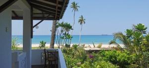 a view of the beach from the balcony of a house at Blackstar Inn in Trincomalee