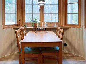 stół jadalny z 2 krzesłami i 2 oknami w obiekcie Holiday home YNGSJÖ III w mieście Yngsjö