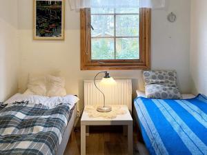 ein Schlafzimmer mit 2 Betten und einem Tisch mit einer Lampe in der Unterkunft Holiday home YNGSJÖ III in Yngsjö