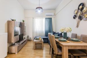 a dining room and living room with a table and a couch at Lovely renovated apartment walk to Acropolis in Athens