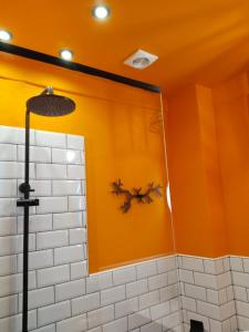 y baño con paredes de color naranja y ducha. en Top Floor Apartment en Komotini