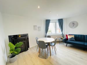 a living room with a table and a blue couch at aday - Blue Sea apartment with balcony in Frederikshavn