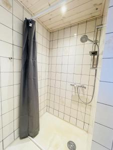 a shower with a black shower curtain in a bathroom at aday - Blue Sea apartment with balcony in Frederikshavn