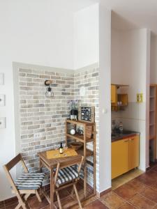 a kitchen with a table and chairs and a brick wall at Apartments Maris in Petrovac na Moru