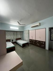 a large room with two beds and a room with at Tripvana Apartment in Nashik +13 photos