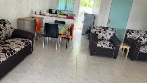een woonkamer met een bank en een tafel en stoelen bij Mapusagas Riverside x2Bedrooms Home away from home #4 Sleeps 2-6 in Apia