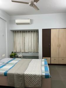 a bedroom with a bed and a ceiling fan at Tripvana Apartment in Nashik