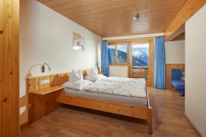 una camera da letto con un letto e una grande finestra di Schuler's Panoramablick a Silbertal
