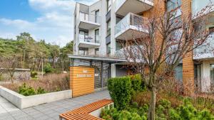 an apartment building with a bench in front of it at Marina Kąty Rybackie Apartamenty PIAMOLA in Kąty Rybackie