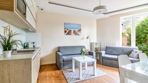 a living room with two chairs and a table at Marina Kąty Rybackie Apartamenty PIAMOLA in Kąty Rybackie