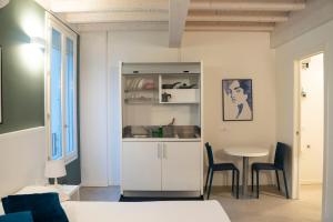 a white kitchen with a table and chairs in a room at Le Stanze di Gianmarmo - Via Marsala in Mirandola