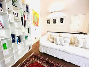 sala de estar con sofá blanco y estanterías en ComeCasa Entire House Port View - Two Bedrooms, en Saint-Tropez