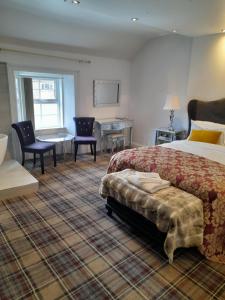 une chambre d'hôtel avec un lit, une table et des chaises dans l'établissement Schooner Hotel, à Alnmouth