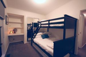 a bedroom with two bunk beds and a mirror at Littlehurst Lodge in Millgrove
