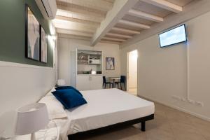Un dormitorio con una gran cama blanca con una almohada azul. en Le Stanze di Gianmarmo - Via Marsala, en Mirandola