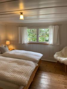 1 dormitorio con 2 camas y ventana en Fischerhäuser Romanshorn, en Romanshorn