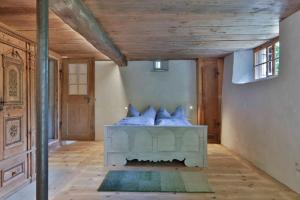 ein Schlafzimmer mit einem Bett mit blauen Kissen darauf in der Unterkunft Ferien im Baudenkmal Toggenburg Bergli in Ebnat