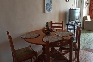 a dining room table with a bowl of fruit on it at SeaShell apartment Sea View, Castle View 200metres from the Beach in Sitia