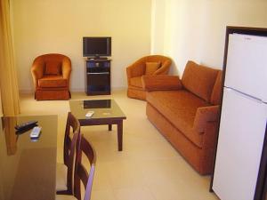 a living room with a couch and a tv at Studio at beautiful beach Kouremenos in Anevató