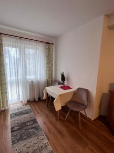 a dining room with a table and chairs and a window at Vila Brad in Predeal