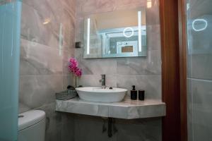 a bathroom with a sink and a mirror at Seashell Luxury Apartment in Nikiti