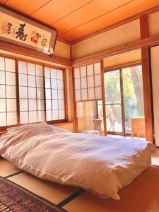 a bedroom with a bed in a room with windows at Diplomat House very close to JR Station in Tokyo