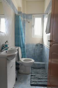 a bathroom with a toilet and a sink and a shower at Loutraki view in Loutraki