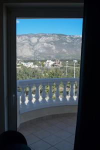 a window with a view of the mountains from a balcony at Loutraki view in Loutraki