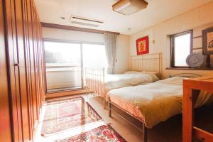 a bedroom with two beds and a window at Diplomat House very close to JR Station in Tokyo